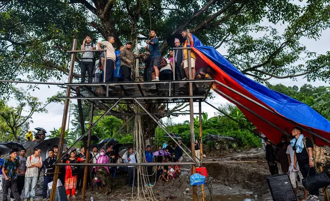 Residents pull the steel wire of a newly installed zipline to help people commute commute across the Trishuli river in the aftermath of flash floods at Bidur in Nepal's Nuwakot district, Nepal, Wednesday, Sept. 2, 2026. (AP Photo/Rajesh Kumar Singh)