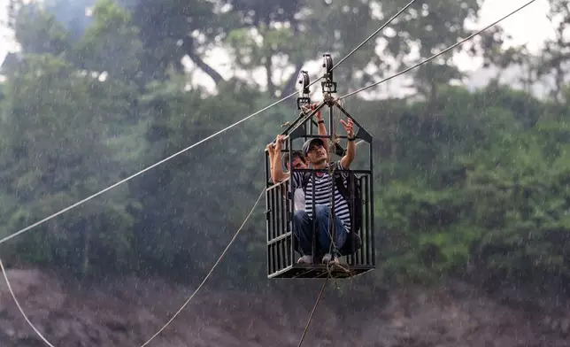 Residents commute across the Trishuli river on a newly installed zipline in the aftermath of flash floods at Bidur in Nepal's Nuwakot district, Nepal, Wednesday, Sept. 2, 2026. (AP Photo/Rajesh Kumar Singh)