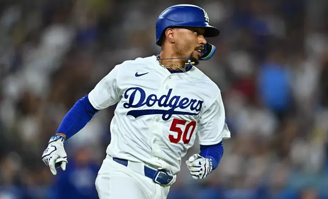 Los Angeles Dodgers' Mookie Betts runs after hitting an RBI single during the third inning of a baseball game against the Washington Nationals, Friday, Sept. 4, 2026, in Los Angeles. (AP Photo/William Liang)