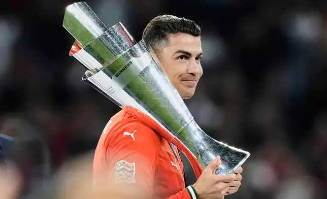 FILE - Portugal's Cristiano Ronaldo holds the trophy after winning the Nations League soccer championship at the Allianz Arena in Munich, Germany, Sunday, June 8, 2025. (AP Photo/Martin Meissner, File)