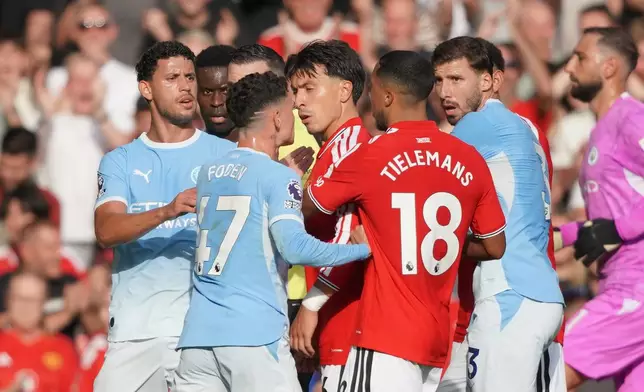 Manchester City's Phil Foden, centre, argues with Manchester United's Lisandro Martinez, centre right, during the English Premier League soccer match between Manchester United and Manchester City in Manchester, England, Sunday, Sept. 13, 2026. (AP Photo/Ian Hodgson)