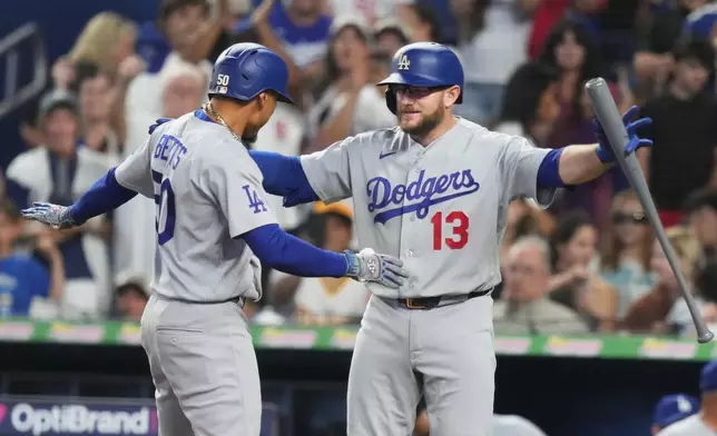 Los Angeles Dodgers' Mookie Betts (50) is met by Max Muncy (13) after hitting also home run during the first inning of a baseball game against the Miami Marlins, Saturday, Sept. 12, 2026, in Miami. (AP Photo/Lynne Sladky)