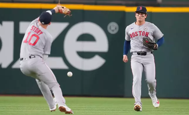 Boston Red Sox left fielder Roman Anthony, right, watches as teammate shortstop Trevor Story (10) is unable to catch a two-run single by Texas Rangers' Corey Seager, not visible, during the second inning of a baseball game Tuesday, Sept. 15, 2026, in Arlington, Texas. (AP Photo/Julio Cortez)