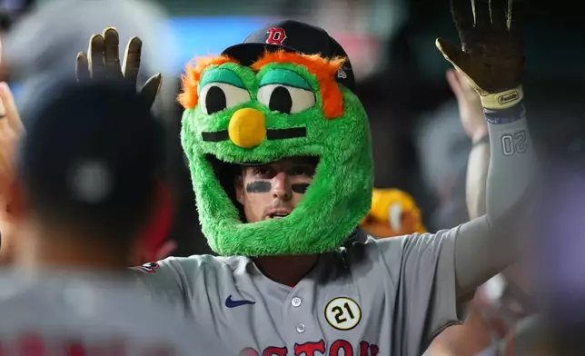 Boston Red Sox's Nick Sogard is greeted in the dugout after hitting a two-run home run off Texas Rangers pitcher Jacob deGrom during the third inning of a baseball game Tuesday, Sept. 15, 2026, in Arlington, Texas. (AP Photo/Julio Cortez)