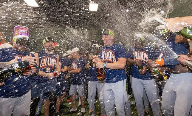Houston Astros celebrate after clinching the AL West division title in a baseball game against the Athletics, Sunday, Sept. 27, 2026, in West Sacramento, Calif. (AP Photo/Sara Nevis)
