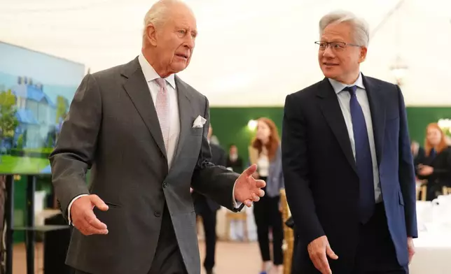 Britain's King Charles III, left, walks with Nvidia chief executive Jensen Huang to a meeting for leaders from the artificial intelligence (AI) sector, government, and thought leaders to discuss how AI can be developed and deployed in ways that benefit society, at Dumfries House in Cumnock, Scotland, Thursday Sept. 17, 2026. (Jonathan Brady/PA via AP, Pool)