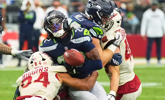 Arizona Cardinals tight end Elijah Higgins (84) causes Seattle Seahawks wide receiver Rashid Shaheed (22) to fumble the ball on a kick return, which is recovered by the Seahawks during the second half of an NFL football game in Glendale, Ariz., Sunday, Sept. 20, 2026. (AP Photo/Ross D. Franklin)