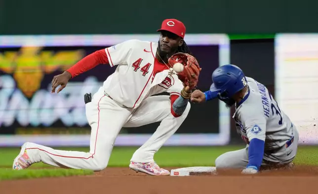 Cincinnati Reds shortstop Elly De La Cruz (44), takes the throw as Los Angeles Dodgers' Teoscar Hernández (37) steals second base during the seventh inning of a baseball game, Monday, Sept. 14, 2026, in Cincinnati. (AP Photo/Carolyn Kaster)