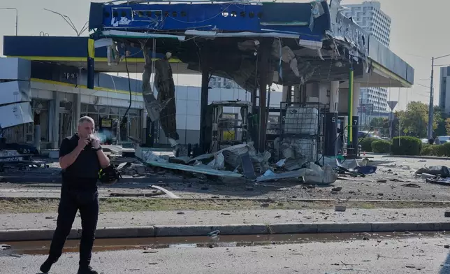 A policeman smokes near a damaged gas station after a Russian drone strike in Kyiv, Ukraine, Friday, Sept. 11, 2026. (AP Photo/Efrem Lukatsky)