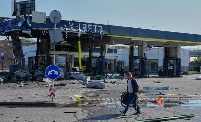 A worker leaves the damaged gas station after a Russian drone strike in Kyiv, Ukraine, Friday, Sept. 11, 2026. (AP Photo/Efrem Lukatsky)