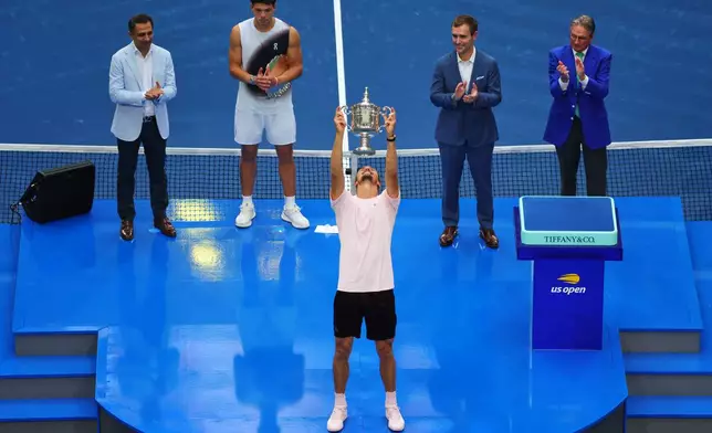 Alexander Zverev, of Germany, holds up his trophy after winning the men's singles final of the U.S. Open tennis championships against Ben Shelton, of the United States, Sunday, Sept. 13, 2026, in New York. (AP Photo/Andres Kudacki)