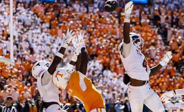 Texas defensive back Jelani McDonald (4) breaks up a Hail Mary pass intended for Tennessee wide receiver Travis Smith Jr. (1) on the last play of the second half of an NCAA college football game, Saturday, Sept. 26, 2026, in Knoxville, Tenn. (AP Photo/Wade Payne)