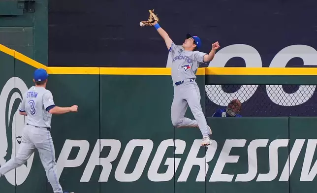 Toronto Blue Jays outfielder fielder Brett Bateman, right, cannot reach the ball at the wall as Myles Straw (3) looks on for a home run by Texas Rangers' Jake Burger during the fourth inning of a baseball game, Sunday, Sept. 20, 2026, in Arlington, Texas. (AP Photo/LM Otero)