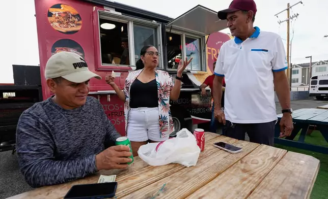 Venezuelans gather outside a food truck on Wednesday, July 15, 2026, in Midvale, Utah. (AP Photo/Gregory Bull)