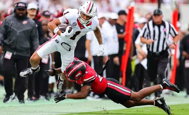 Georgia wide receiver Talyn Taylor (1) gets tackled by Western Kentucky defensive back Lataj Wright, right, during the first half of an NCAA college football game, Saturday, Sept. 12, 2026, in Athens, Ga. (AP Photo/Colin Hubbard)