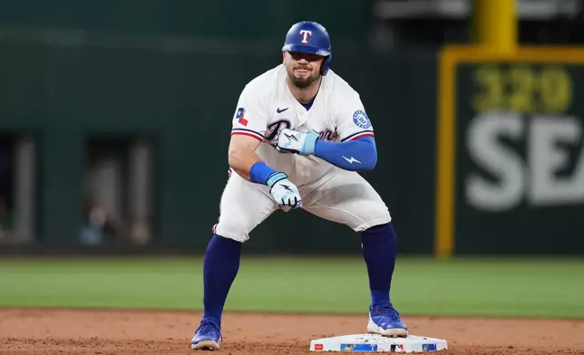 Texas Rangers' Jake Burger celebrates his ground-rule double that scored Justin Foscue in the first inning of a baseball game against the Boston Red Sox Wednesday, Sept. 16, 2026, in Arlington, Texas. (AP Photo/Tony Gutierrez)