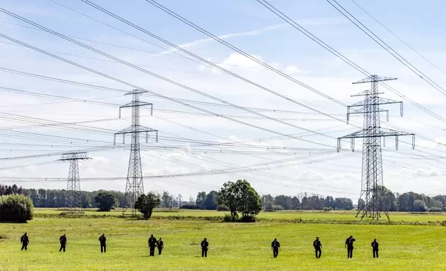 A police unit of 100 officers is conducting a large-scale search of the area surrounding the act of sabotage against the power grid in southern Brandenburg, near Turnow-Preilack, Germany, as police on the scene are continuing to search for clues to identify the perpetrators. (Frank Hammerschmidt/dpa via AP)