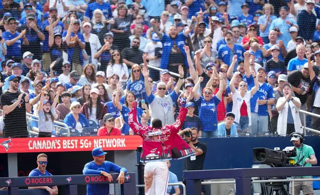 Toronto Blue Jays' Vladimir Guerrero Jr., center bottom, acknowledges the fans after hitting a solo home run against the Baltimore Orioles during the fifth inning of a baseball game in Toronto, Sunday, Sept. 13, 2026. (Nathan Denette/The Canadian Press via AP)