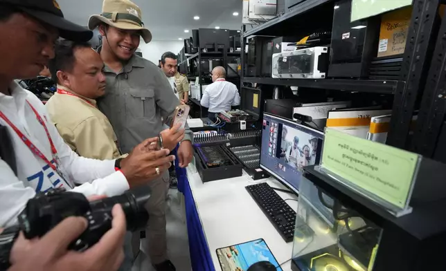 Journalists test AI software used to manipulate images at Phnom Penh Municipal Police headquarters following an operation against scam centers in Phnom Penh, Cambodia, Tuesday, Sept. 22, 2026. (AP Photo/Heng Sinith)