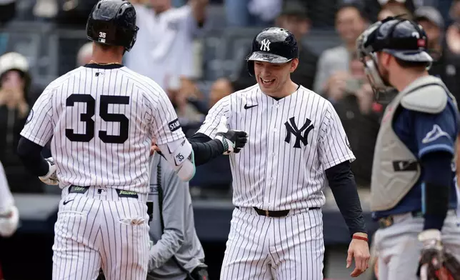 New York Yankees' Cody Bellinger (35) is congratulated by Ben Rice in front of Tampa Bay Rays catcher Liam Hicks, right, after hitting a two-run home run in the fourth inning during the first baseball game of a doubleheader Tuesday, Sept. 22, 2026, in New York. (AP Photo/Adam Hunger)