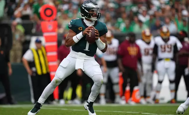 Philadelphia Eagles quarterback Jalen Hurts (1) looks to pass against the Washington Commanders during the first half of an NFL football game, Sunday, Sept. 13, 2026, in Philadelphia. (AP Photo/Matt Rourke)