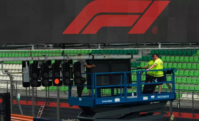 Workers set up trackside signage during preparations for the Bahrain Grand Prix in Malaysia at the Sepang International Circuit in Sepang, Malaysia, Wednesday, Sept. 30, 2026. (AP Photo/Vincent Thian)