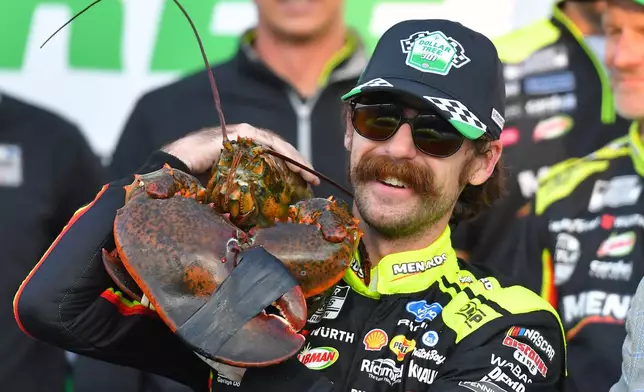 Ryan Blaney displays a lobster, a Victory Lane tradition at New Hampshire Motor Speedway, after winning a NASCAR Cup Series auto race, Sunday, Aug. 23, 2026, at the speedway in Loudon, N.H. (AP Photo/Steven Senne)