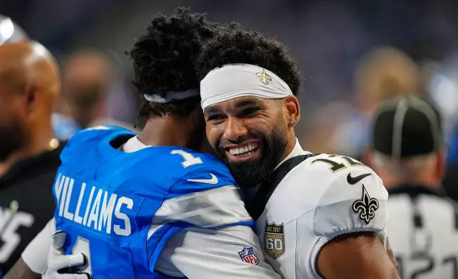 Detroit Lions wide receiver Jameson Williams hugs New Orleans Saints wide receiver Chris Olave (12) before an NFL football game, Sunday, Sept. 13, 2026, in Detroit. (AP Photo/Paul Sancya)
