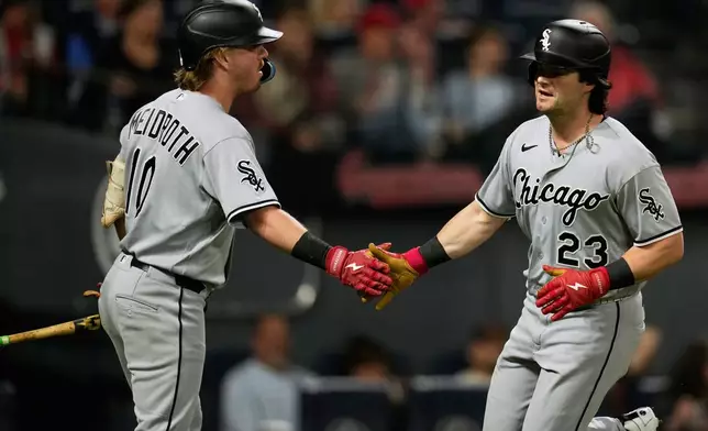 Chicago White Sox's Andrew Benintendi (23) is congratulated by Chase Meidroth, left, after scoring in the sixth inning of a baseball game against the Cleveland Guardians in Cleveland, Monday, Sept. 14, 2026. (AP Photo/Sue Ogrocki)