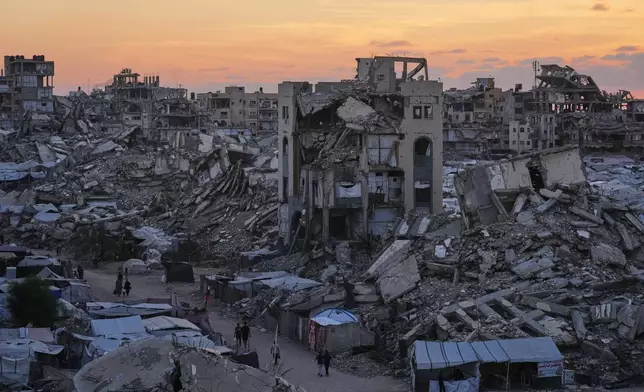Palestinians walk amid war-damaged buildings in Gaza City, Wednesday, Sept. 23, 2026. (AP Photo/Jehad Alshrafi)