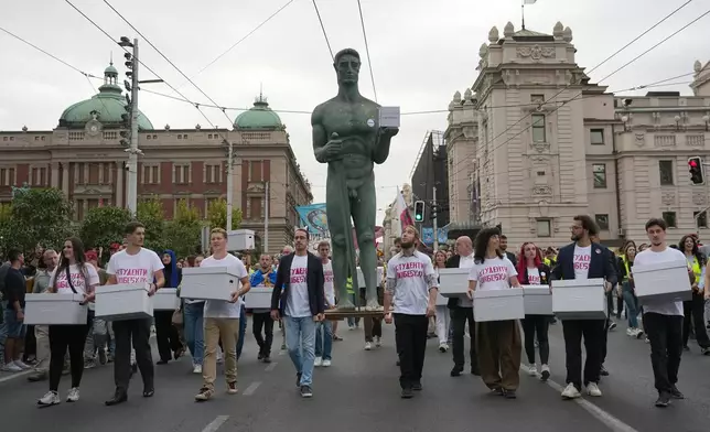 Political candidates, students and citizens carry signatures for the "Student list - Students win" to the Republic Election Commission towards participation in the upcoming parliamentary elections in Belgrade, Serbia, Monday, Sept. 14, 2026. (AP Photo/Darko Vojinovic)