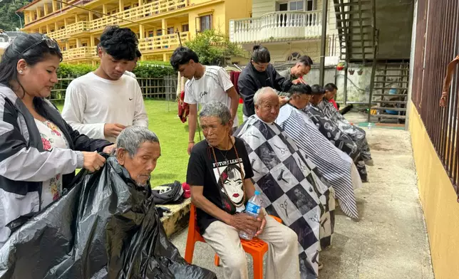 Survivors have their hair cut at a monastery where people are taking refuge in Kathmandu, Nepal, Monday, Aug. 31, 2026. (AP Photo/Niranjan Shrestha)