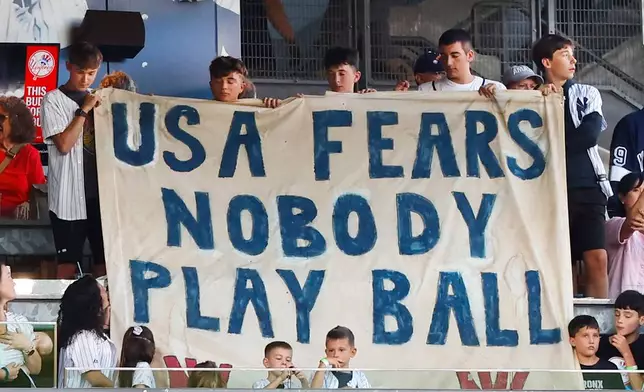 New York Yankees fans share a message during a 9/11 ceremony before baseball game against the New York Mets, Friday, Sept. 11, 2026, in New York. (AP Photo/Noah K. Murray)