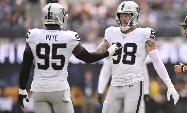 Las Vegas Raiders defensive end Maxx Crosby (98) and defensive end Kwity Paye (95) shake hands after a defensive stop during the first half an NFL football game against the Los Angeles Chargers in Inglewood, Calif., Sunday, Sept. 20, 2026. (AP Photo/Katie Chin)