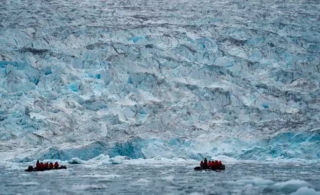 FILE - Two groups from the Poseidon Expeditions tour company look at a glacier in the Scoresby Sund, Sept. 7, 2023, in Greenland. (AP Photo/Chris Szagola, File)