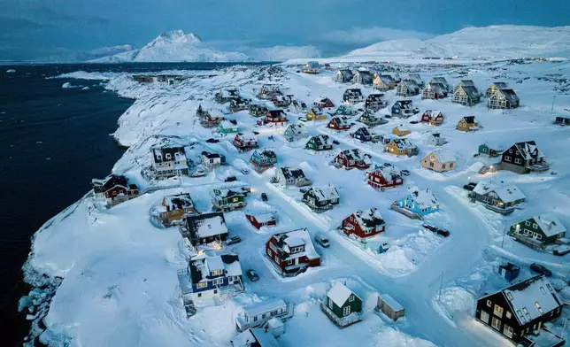 FILE - Houses covered in snow are seen on the coast of a sea inlet of Nuuk, Greenland, March 7, 2025. (AP Photo/Evgeniy Maloletka, File)