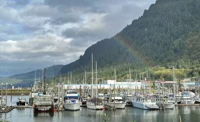 This photo taken with a smartphone shows a partial rainbow arching over boats docked in a harbor in Juneau, Alaska, Thursday, Sept. 24, 2026. (AP Photo/Becky Bohrer)