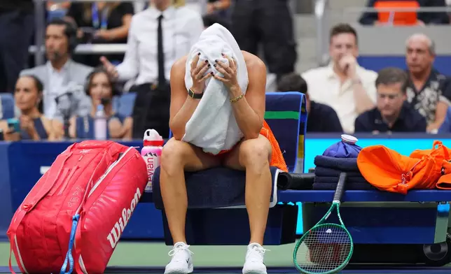 Aryna Sabalenka, of Belarus, sits with a towel on her head during a break from play during the women's singles final of the U.S. Open tennis championships against Elena Rybakina, of Kazakhstan, Saturday, Sept. 12, 2026, in New York. (AP Photo/Kirsty Wigglesworth)