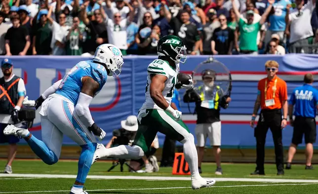 New York Jets tight end Kenyon Sadiq (16) runs in for a touchdown pursued by Tennessee Titans defensive end Jermaine Johnson II (11) during the first half of an NFL football game, Sunday, Sept. 13, 2026, in Nashville, Tenn. (AP Photo/George Walker IV)