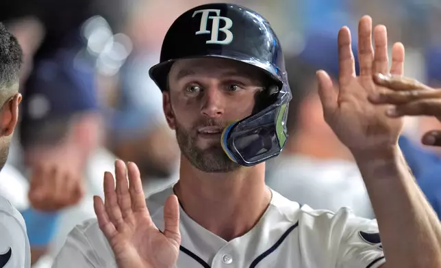 Tampa Bay Rays' Kenny Piper celebrates in the dugout after scoring on a sacrifice fly by Nick Madrigal off Houston Astros pitcher Bennett Sousa during the seventh inning of a baseball game Saturday, Sept. 12, 2026, in St. Petersburg, Fla. (AP Photo/Chris O'Meara)