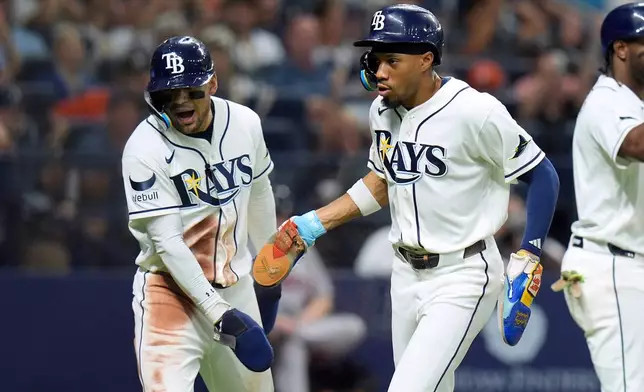 Tampa Bay Rays' Chandler Simpson, right, and Victor Mesa Jr. celebrate after scoring on a two-run single by Richie Palacios off Houston Astros pitcher Peter Lambert during the fifth inning of a baseball game Saturday, Sept. 12, 2026, in St. Petersburg, Fla. (AP Photo/Chris O'Meara)