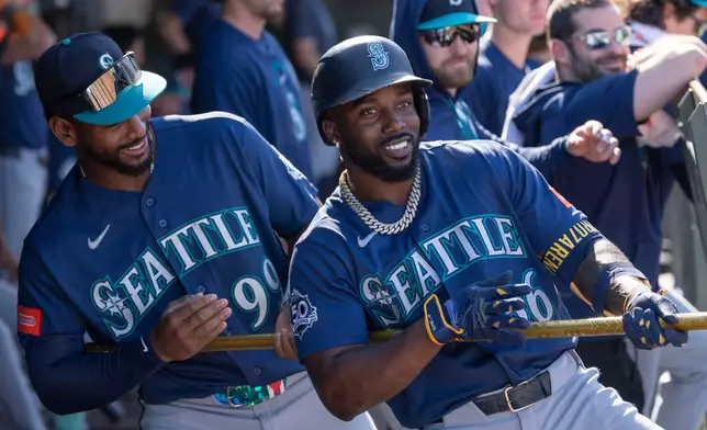 Seattle Mariners' Randy Arozarena, right, jokes with Lazaro Montes (99) after hitting a home run during the eighth inning of a baseball game against the Athletics, Sunday, Sept. 13, 2026, in West Sacramento, Calif. (AP Photo/Sara Nevis)