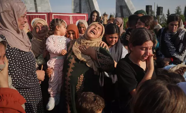 Women mourn during a mass funeral for prisoners who died in a fire that broke out during unrest at the local prison in the predominantly Kurdish city of Kobani, northern Syria, Monday, Sept. 14, 2026. (AP Photo/Baderkhan Ahmad)