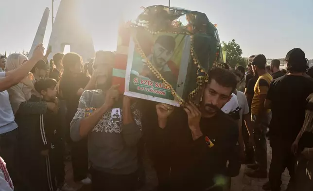 Mourners carry the coffin of one of the prisoners who died in a fire that broke out during unrest at the local prison, during a mass funeral in the predominantly Kurdish city of Kobani, northern Syria, Monday, Sept. 14, 2026. (AP Photo/Baderkhan Ahmad)