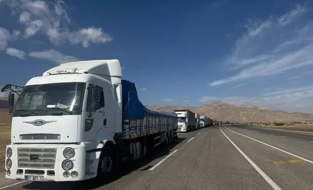 Trucks queue on the road leading to the Gurbulak border crossing on the Turkish-Iranian border in Agri province, eastern Turkey, Tuesday, Sept. 22, 2026. (AP Photo/Serra Yedikardes)
