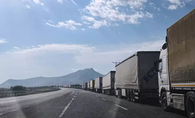 Trucks queue on the road leading to the Gurbulak border crossing on the Turkish-Iranian border in Agri province, eastern Turkey, Tuesday, Sept. 22, 2026. (AP Photo/Serra Yedikardes)