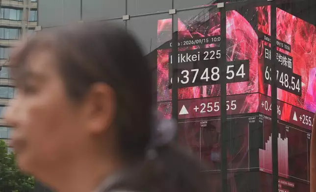 A person stands in front of an electronic stock board showing Japan's Nikkei index at a securities firm Tuesday, Sept. 15, 2026, in Tokyo. (AP Photo/Eugene Hoshiko)