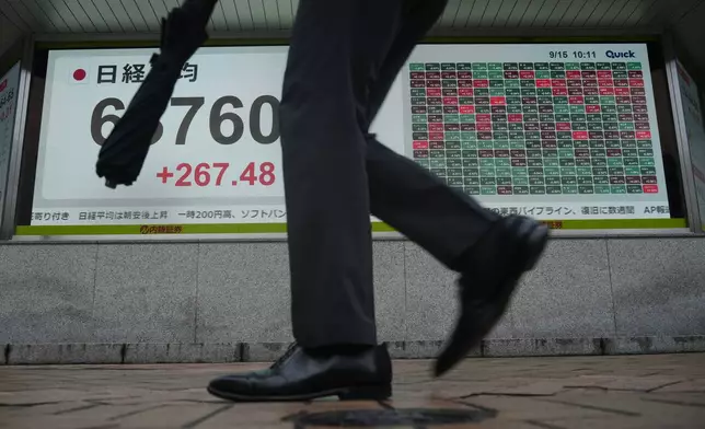 A person walks in front of an electronic stock board showing Japan's Nikkei index at a securities firm Tuesday, Sept. 15, 2026, in Tokyo. (AP Photo/Eugene Hoshiko)
