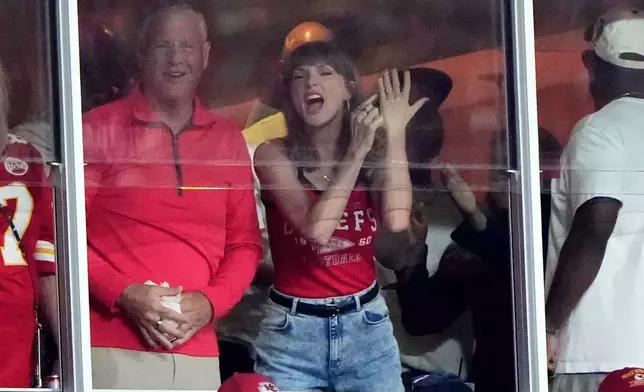 Taylor Swift celebrates with her father, Scott Swift, left, after a score by Kansas City Chiefs tight end Travis Kelce during the first half of an NFL football game between the Kansas City Chiefs and the Indianapolis Colts Sunday, Sept. 20, 2026, in Kansas City, Mo. (AP Photo/Charlie Riedel)