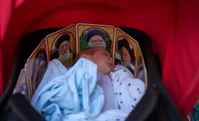 A Jewish baby sleeps in a stroller decorated with pictures of rabbis, in Jerusalem's Mea Shearim neighborhood, Wednesday, Sept. 23, 2026. (AP Photo/Ohad Zwigenberg)